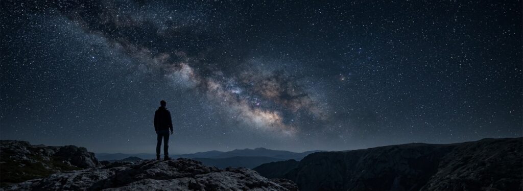 Lone human observer beneath a star-filled night sky contemplating consciousness, self-awareness, reality, and humanity's place in the universe